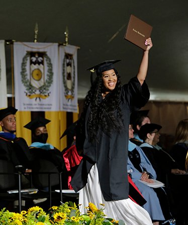 Student on stage at a commencement ceremony.