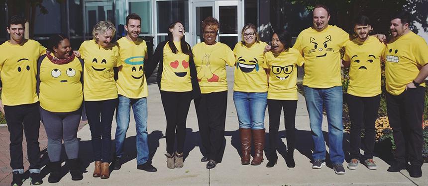 OSLP staff stands together, wearing yellow shirts with funny faces on them.
