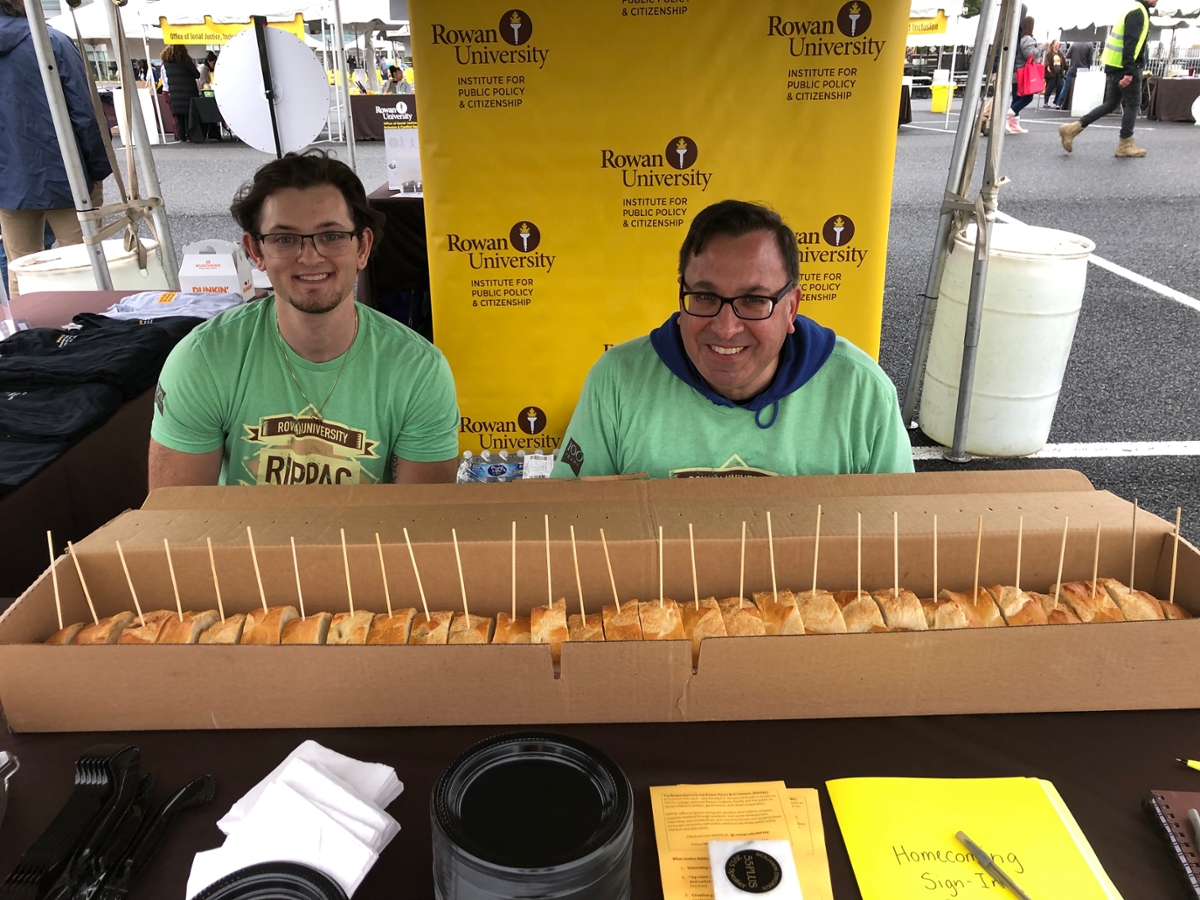 Reilly Kerr '24 and Dr. Dworkin pose with RIPPAC's six-foot hoagie at the Homecoming table