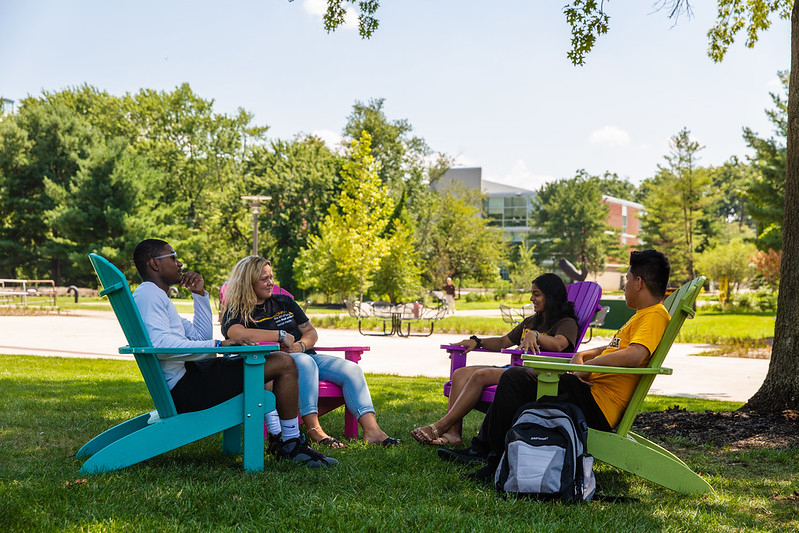 students sitting in chairs outside