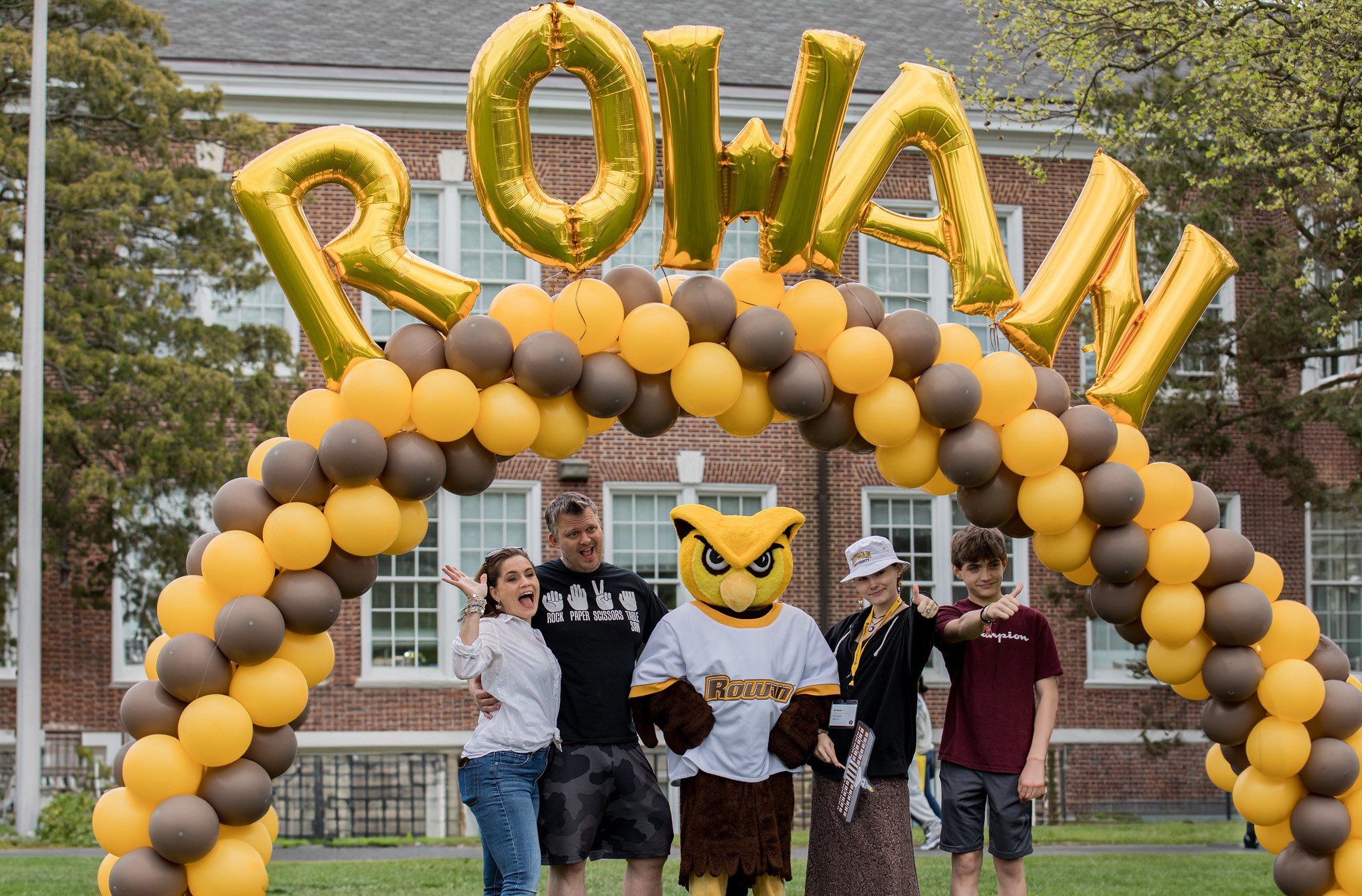 A group of Rowan alumni under a Rowan balloon arch.