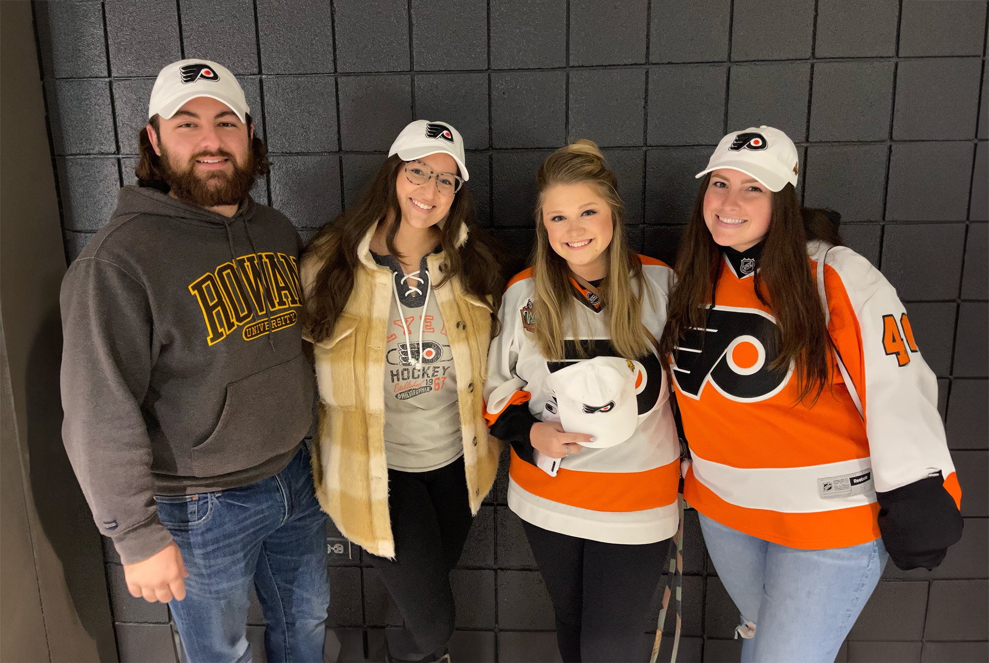 A group of four Rowan students wearing Flyer apparel.