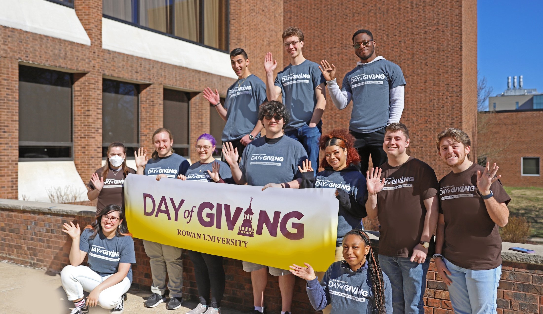 A group of Rowan University students holding a day of giving banner.