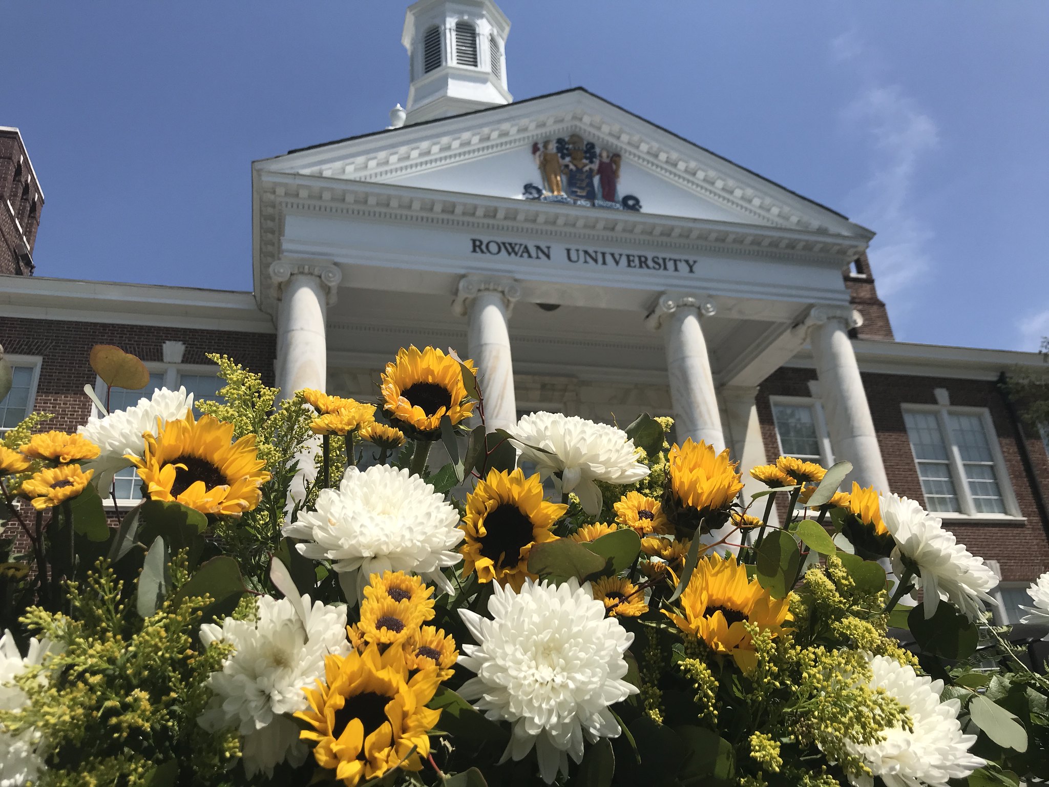 Rowan Univeristy's Bunce Hall with sunflowers in front.