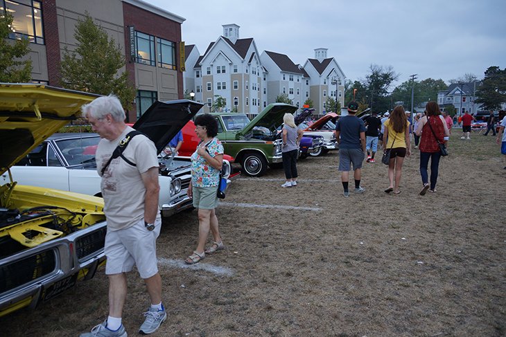 Community members looks at cars at the car show.