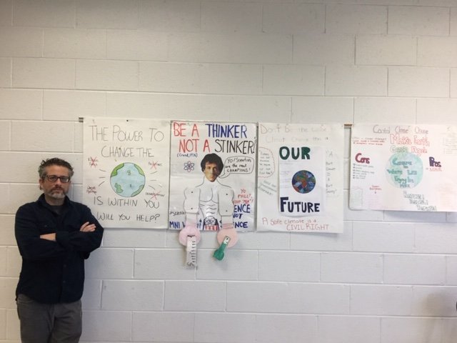 Elliott Karetny picture with students posters
