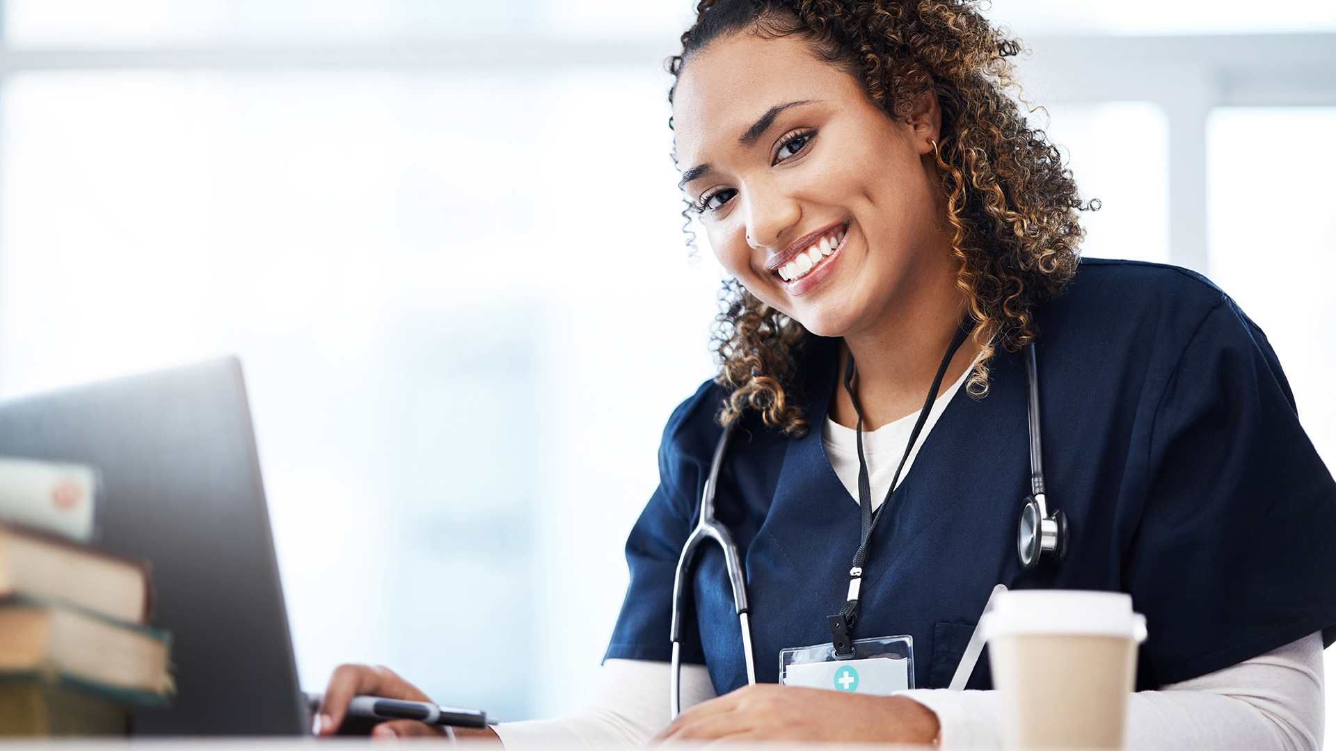 Nurse with laptop smiling.