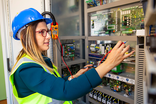 Electrician testing wires with multimeter.