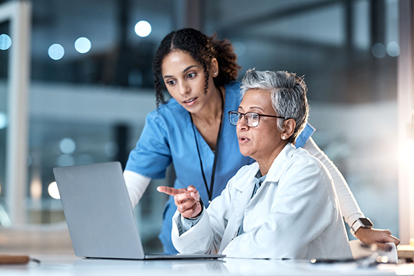 nurses discussing details on laptop