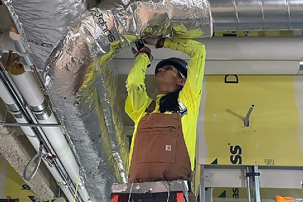 construction worker checking on hvac efficiency