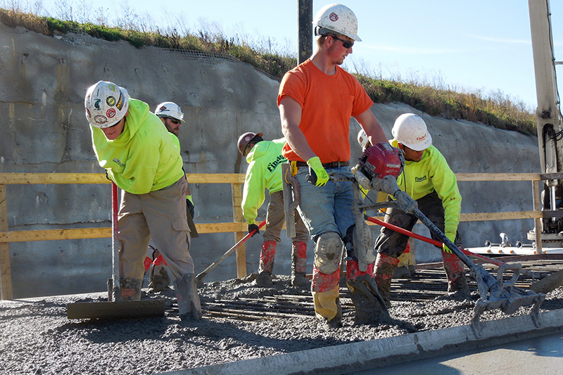 masons working on construction site, passing bricks