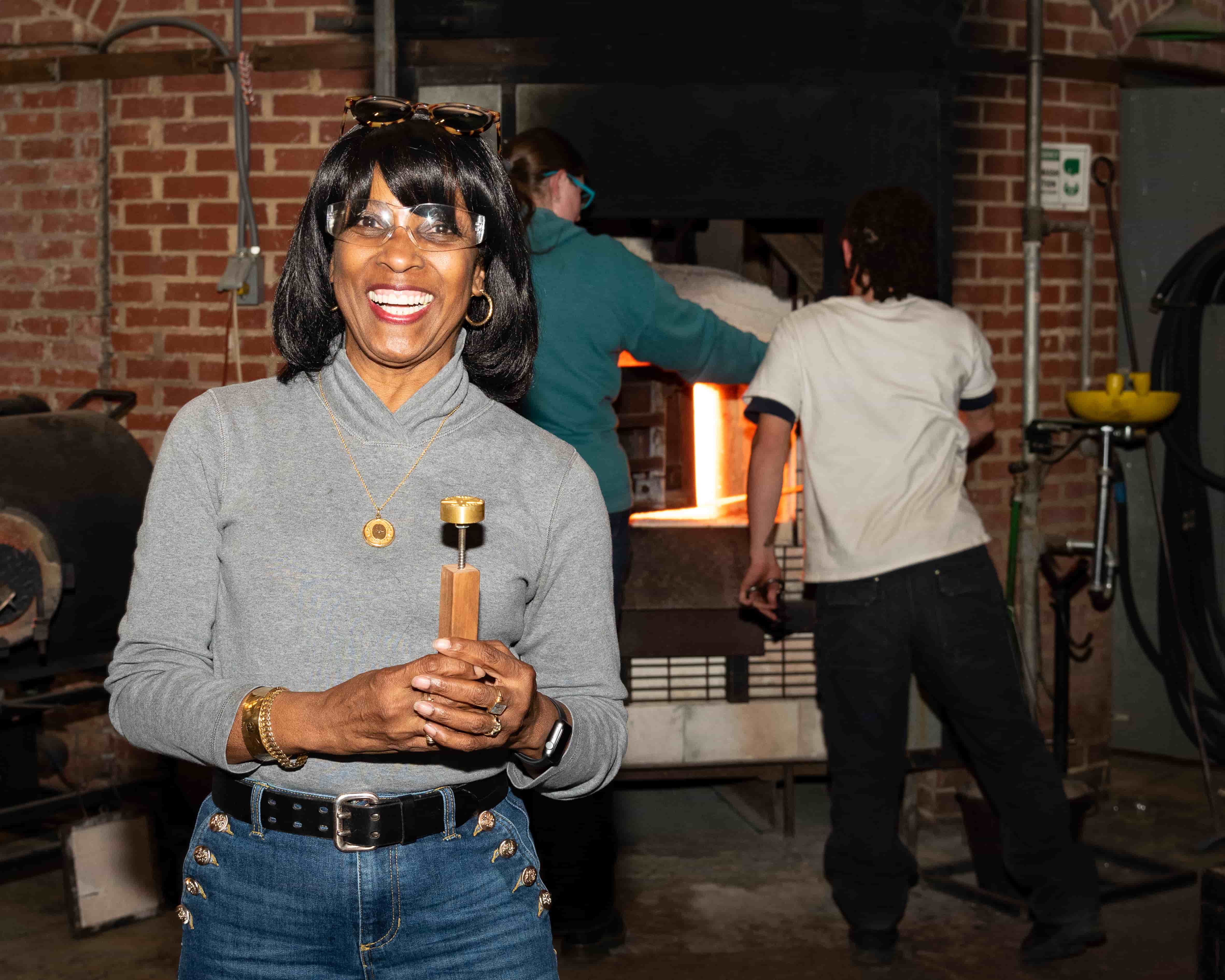 Lady wearing goggles & holding glass stamp