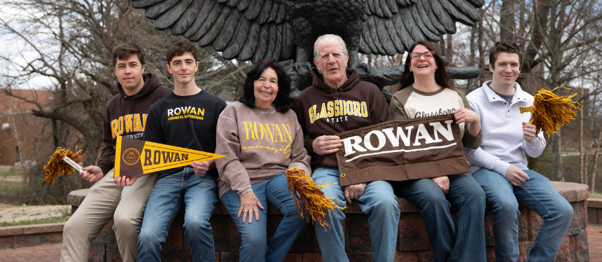 Photo of the 2024 Legacy Family Competition winners in front of the owl statue on campus
