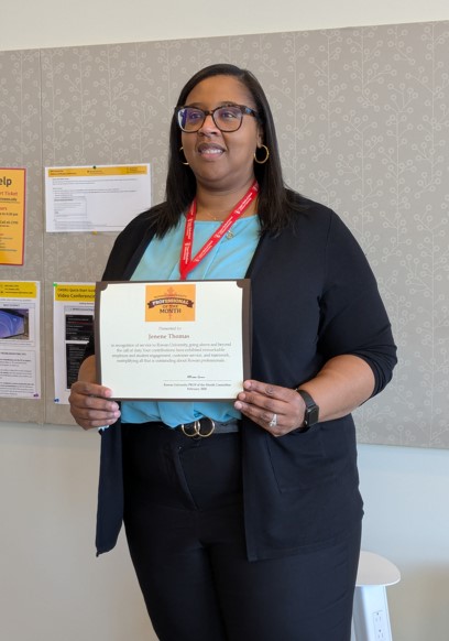 Jenene Thomas holding a Prof of the Month Certificate 