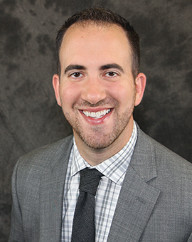 Chris D'Angelo smiling in a suit