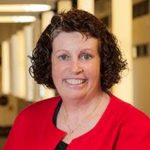 Dr. Marybeth Walpole smiling in red