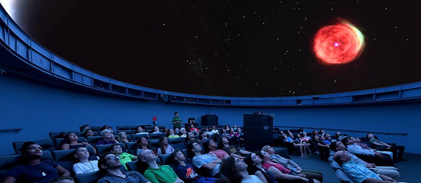 An audience watches a show in the planetarium.