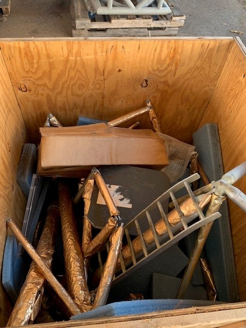A box filled with loose exhibit pieces. The ladder and some of the lander's legs are visible.