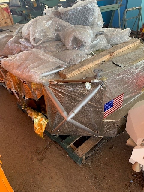 The base of the lunar lander showing torn mylar and extra pieces wrapped in bubble wrap.