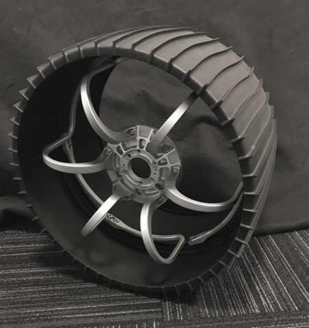 Picture of a model of Perseverance's wheel on a gray background