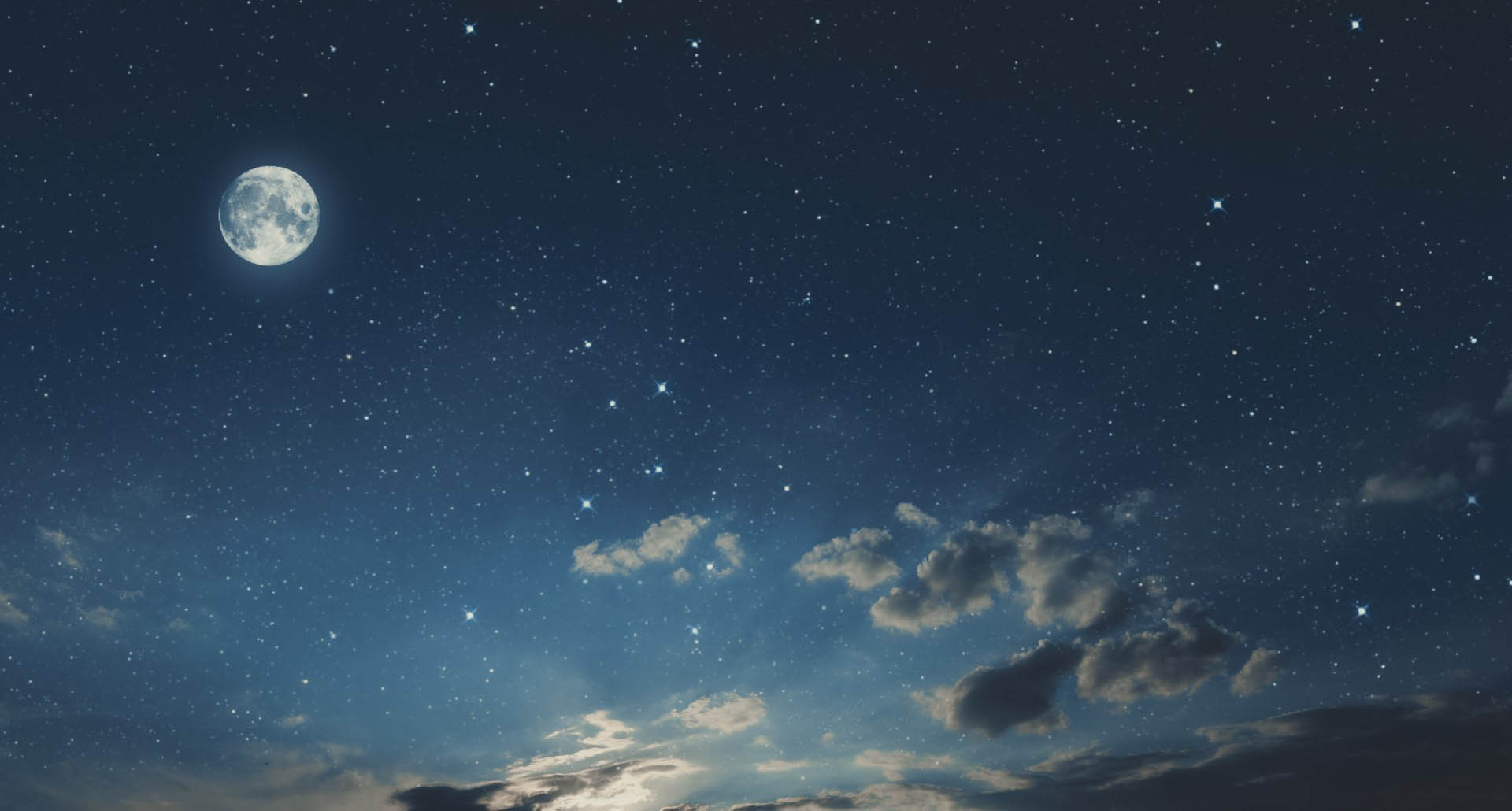 Artistic view of the full Moon and clouds against a starry sky.