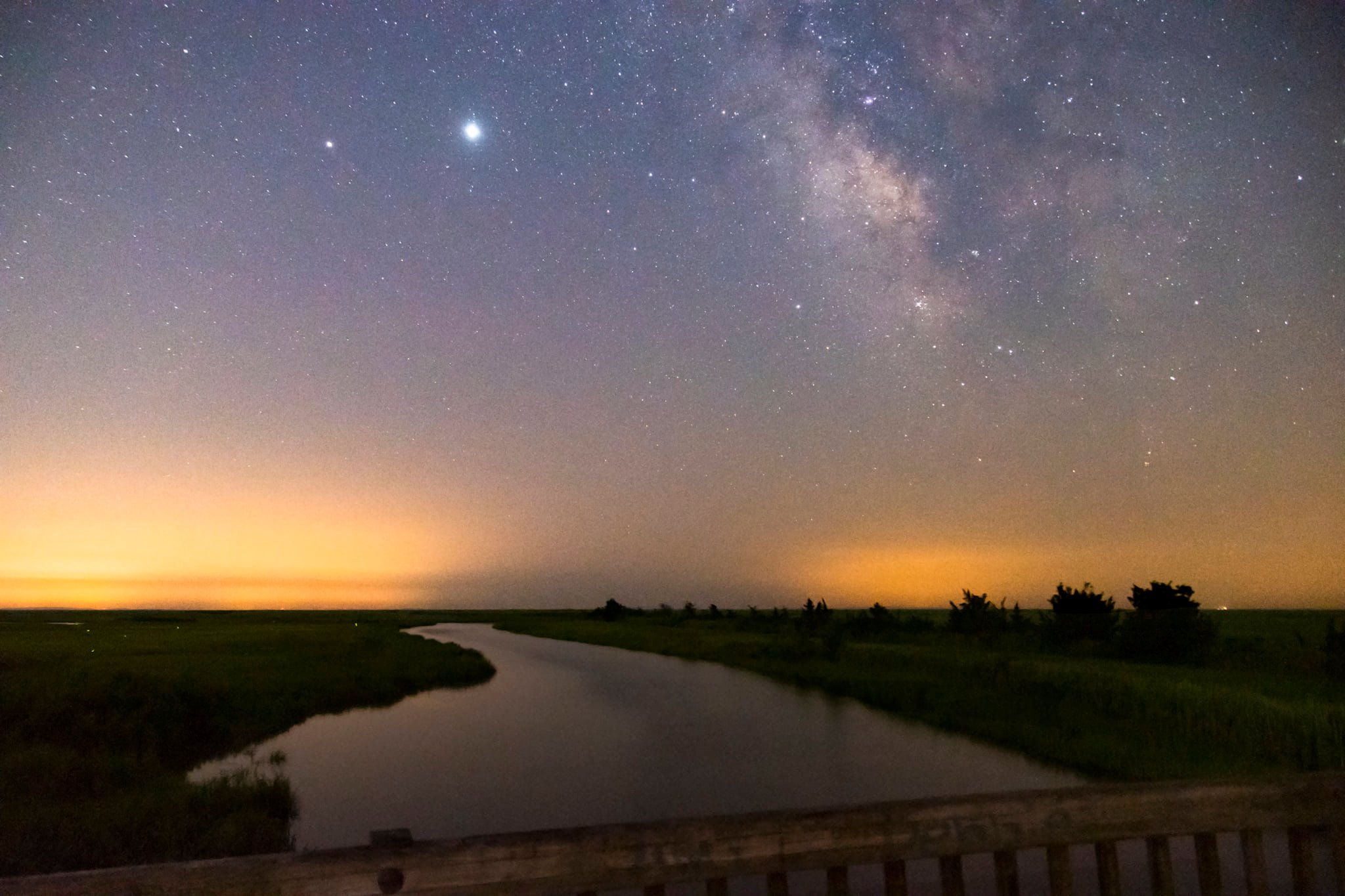 Two bright planets shine in a sky full of stars. The dusty arm of the Milky Way and the Delaware River are also visible.