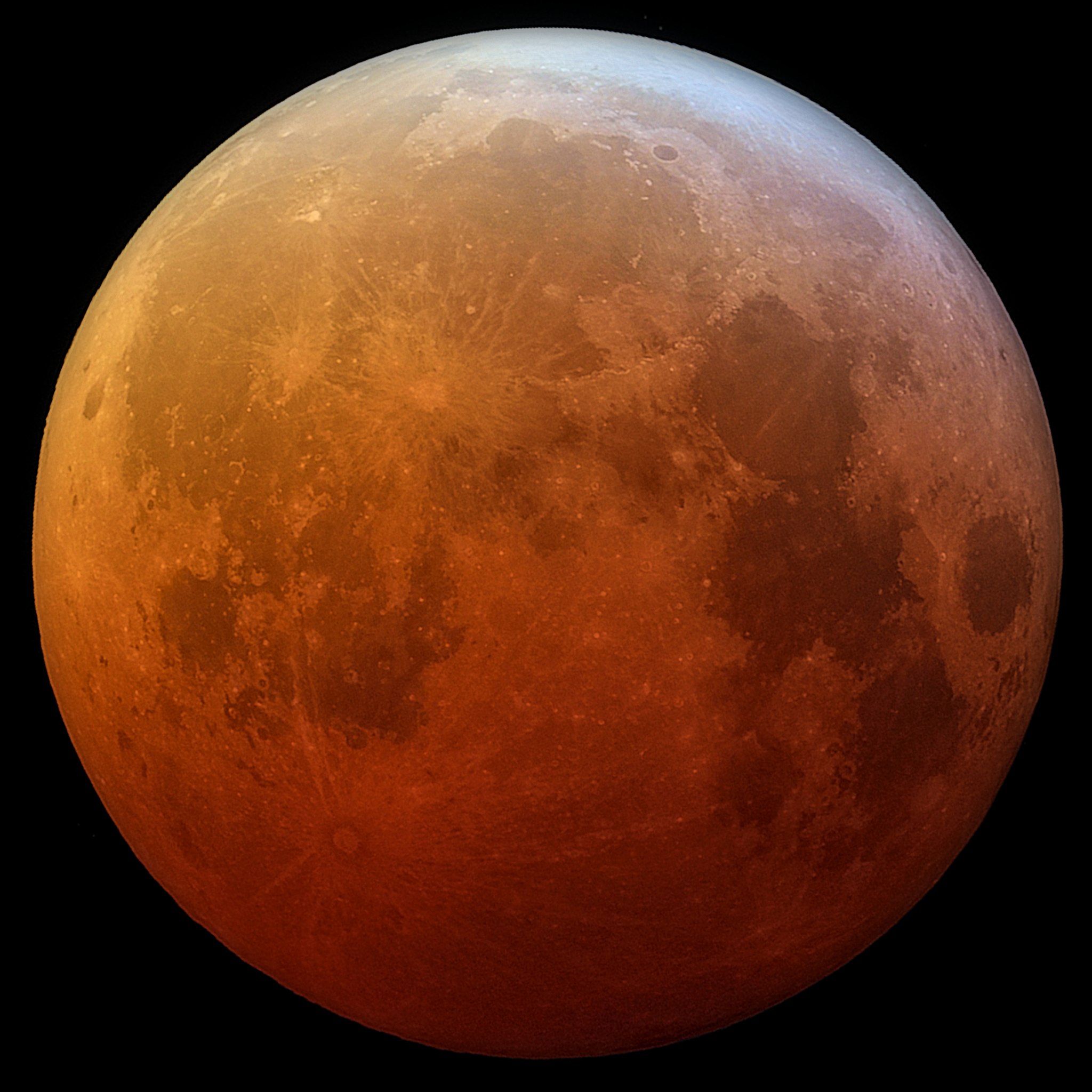 A detailed look at the Moon during a total lunar eclipse. It has an eerie orangish-red color.