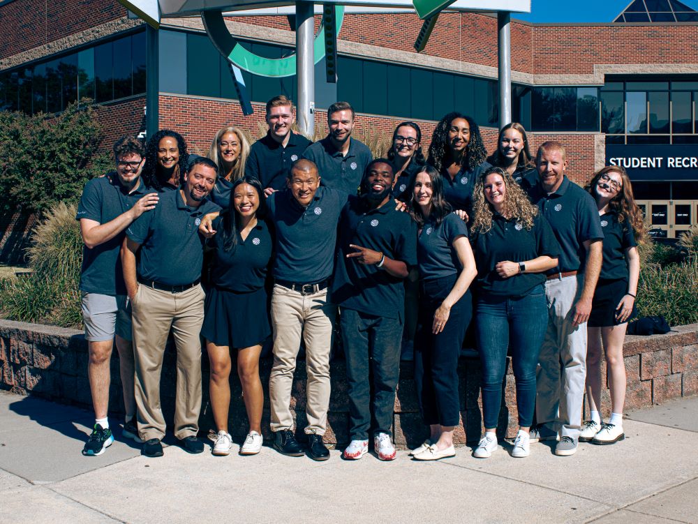 photo of staff in standing in front of rec center sculpture