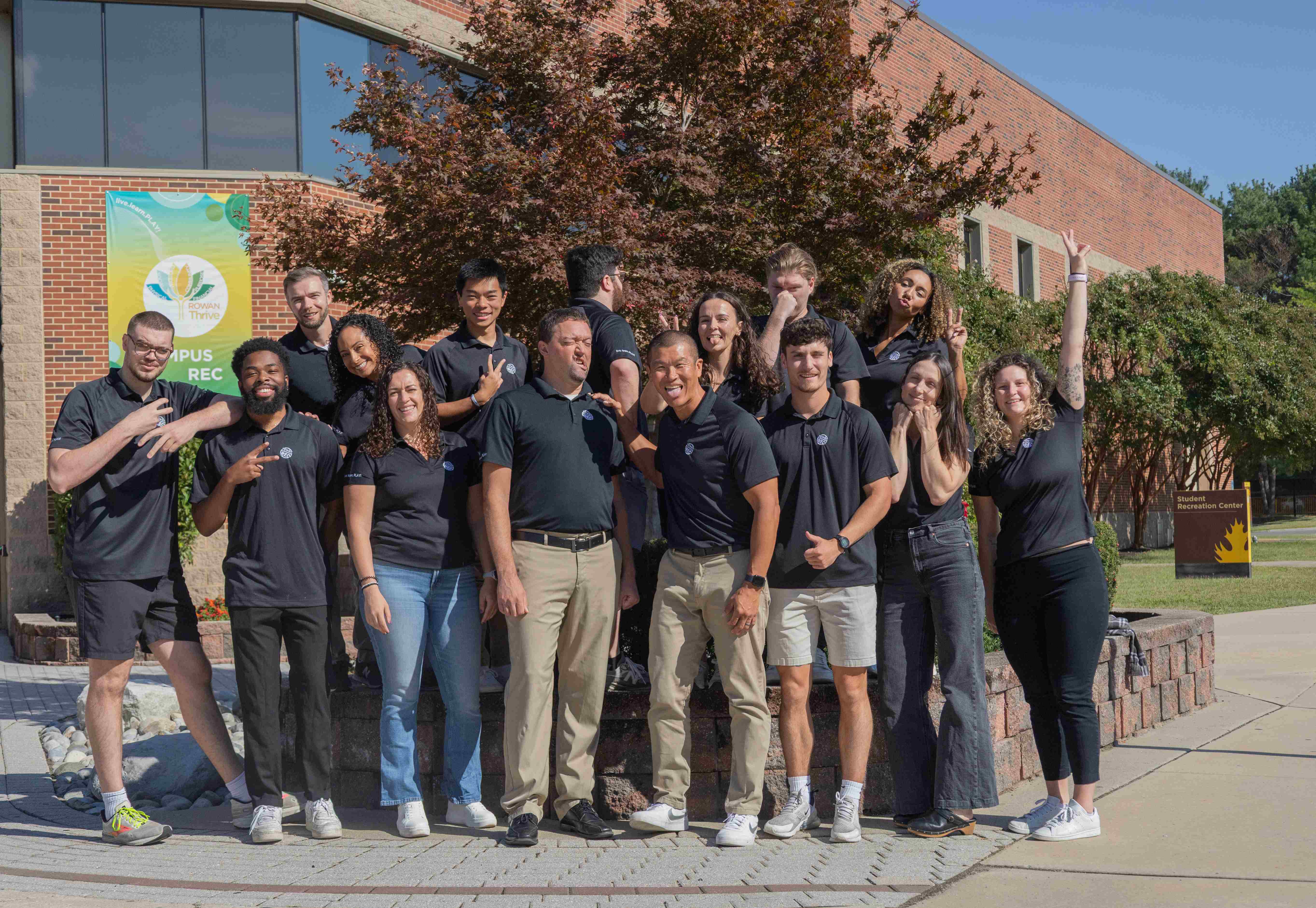 photo of staff in standing in front of rec center sculpture
