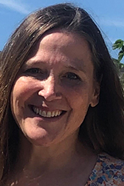 Shari Willis smiles while standing outside and wearing a floral blouse