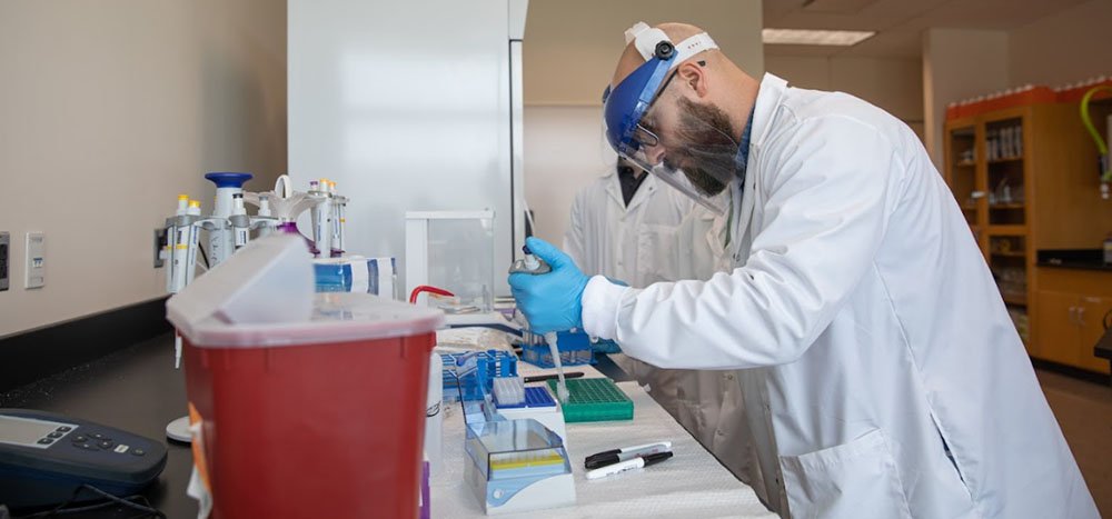 a faculty member works with collected items in a lab