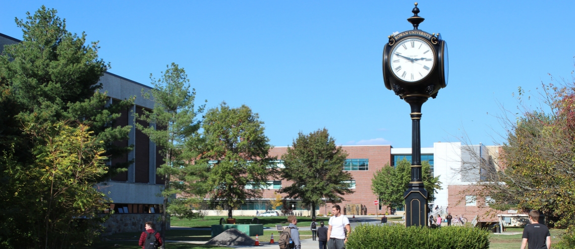 The old clock tower stands in the middle of the campus, with students walking around. James and Robinson are visible in the background.
