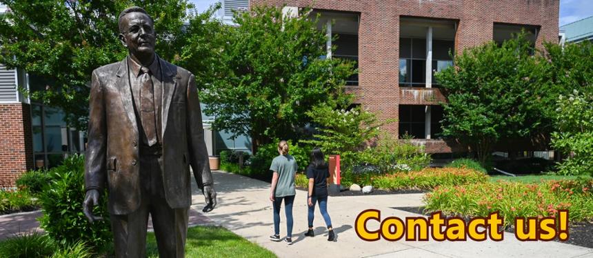 Photo of Henry Rowan Statue with students walking past. Image is captioned with "Contact Us"