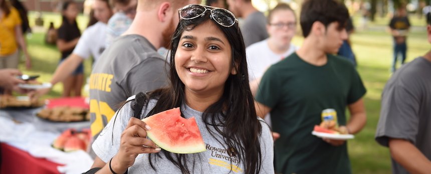 Rowan student eating watermelon at campus event