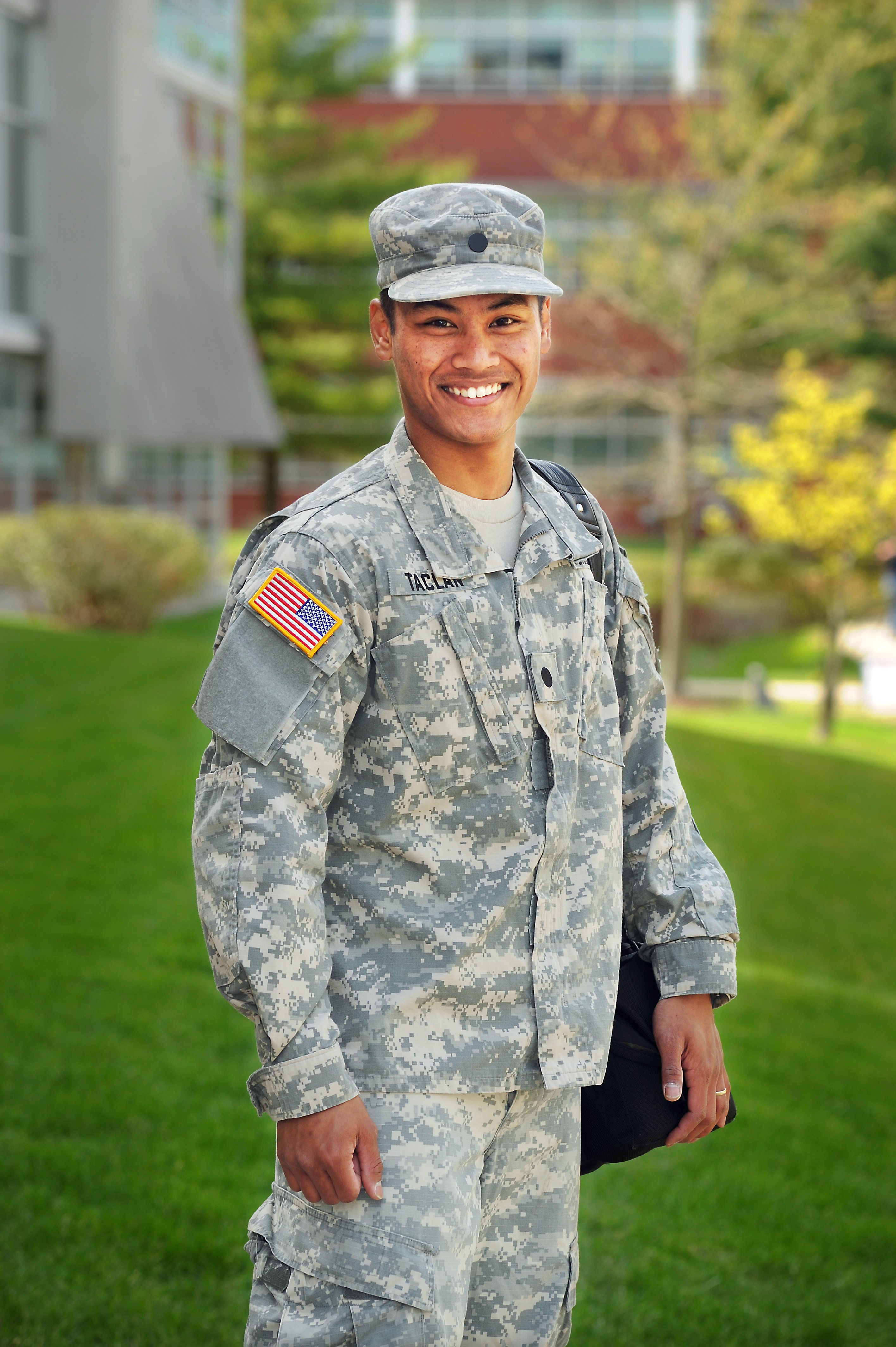 Solider standing outside of library with bookbag