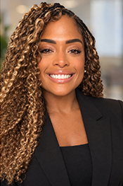SNHP Interim Dean, Margarita David, smiles at the camera while wearing a black bouse and black suit jacket